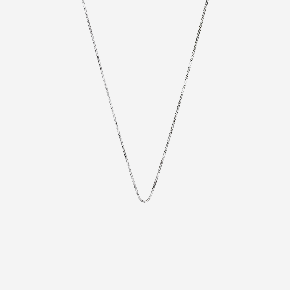 Silver chain necklace on a light gray background