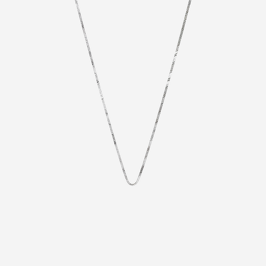 Silver chain necklace on a light gray background